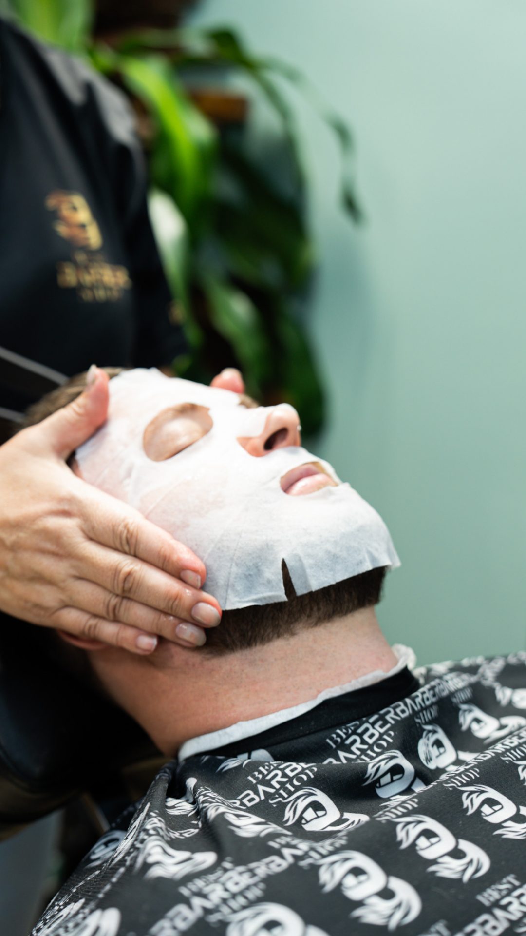 Client relaxing in a sheet face mask during a facial