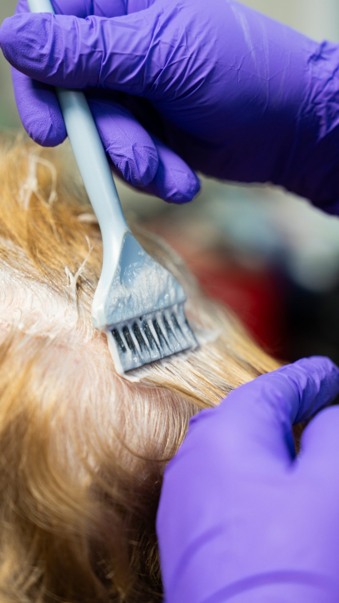 Colorist applying hair color with a brush