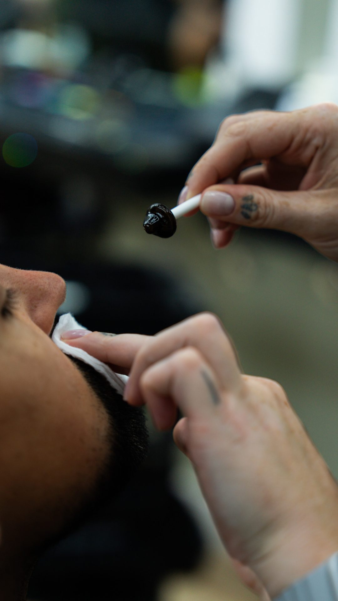 Barber waxing a client’s nose