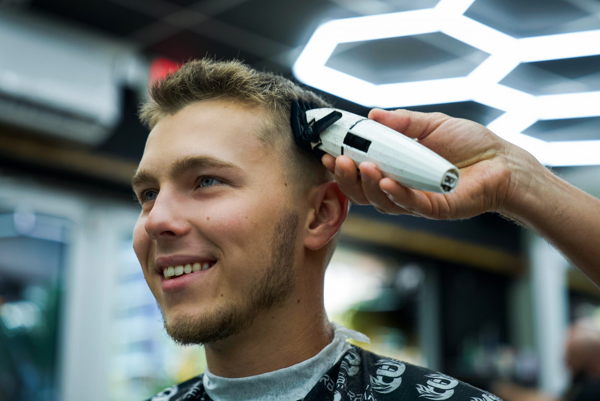 Smiling client getting a haircut with clippers